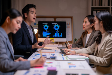 There are four people in total, with one man standing and talking to the group