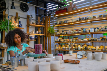 African woman make earth ware at workshop.