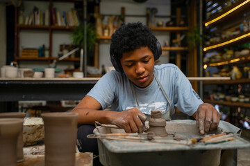 African man make earth ware at workshop.
