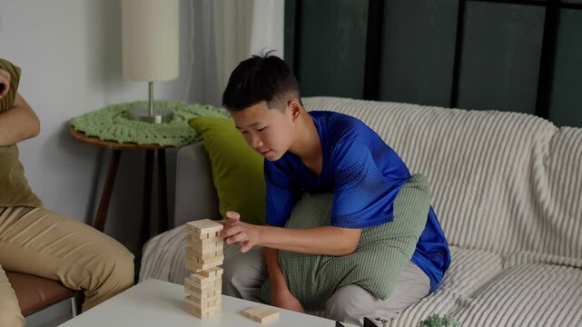 Brother and younger brother play board games together.