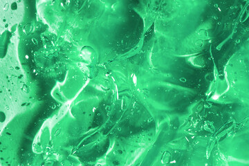 Liquid gel abstract cosmetic in green background. Smear of transparent moisturizing product of aloe