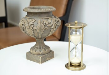 Decorative vase and hourglass on a modern table  