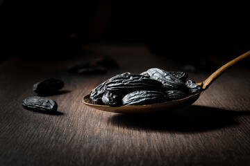 Tonkabohnen auf einem goldenen löffel, chiaroscuro