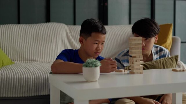 Brother and younger brother play board games together.