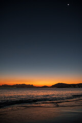 Naklejka premium Sunset Over Itaipu Beach with Crescent Moon in the Sky - Niteroi, Rio de Janeiro, Brazil