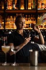 Smiling woman bartender preparing cocktail at bar counter