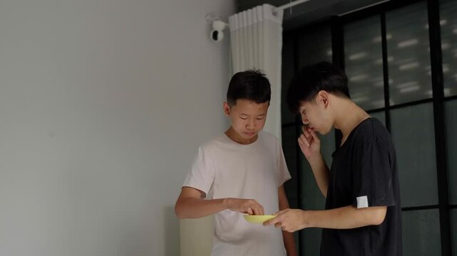 Brother sitting and eating snacks at home.