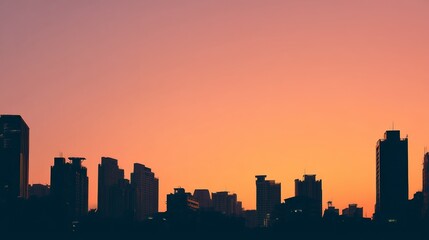 City skyline silhouette against a warm dusk sky, urban simplicity meets serene twilight.