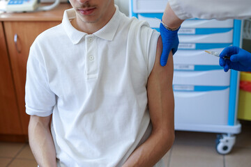 Young man receiving an injection during a vaccination procedure