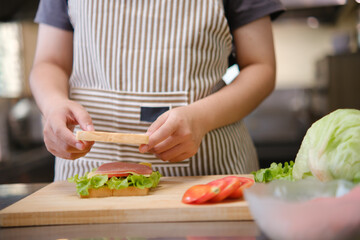 Focused chef carefully a gourmet sandwich