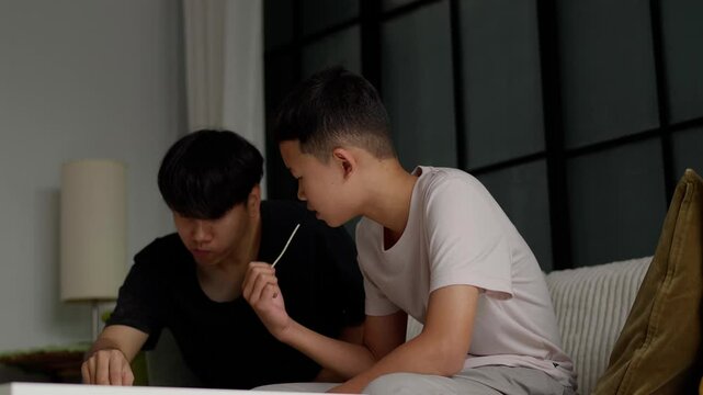 Brother sitting and eating snacks at home.
