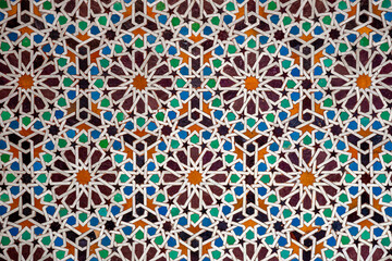 Colorful traditional Moroccan zellije mosaic pattern in Marrakesh, Morocco, showcasing intricate Islamic geometric art and centuries-old craftsmanship hand-cut tiles, reflecting cultural heritage.