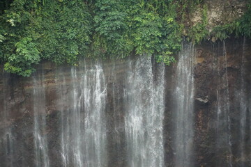 Majestic waterfall cascading down rocky cliff tropical forest nature photography scenic view tranquil wilderness