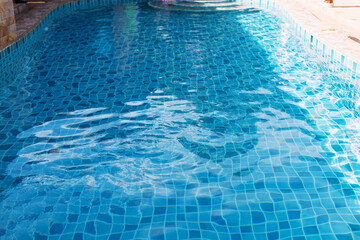 The water in the swimming pool is blue and the floor tiles below.