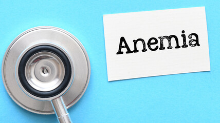 ANEMIA word on a small piece of paper and blue background.