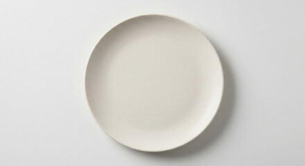 Empty Ceramic Plate Sits on White Surface, Showing Simplicity and Cleanliness