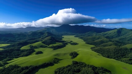 Obraz premium Lush green valleys and mountains under a vast cloud