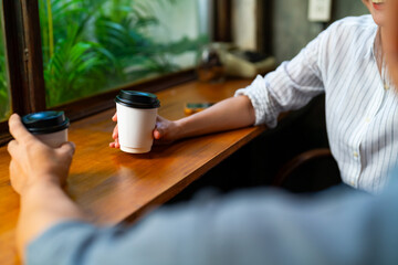 Asian businessman and businesswoman meeting corporate business at coffee shop. Happy couple relax and enjoy drinking coffee together at cafe. Small business food and drink restaurant concept.