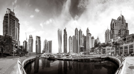 Fototapeta premium Panoramic view of Dubai Marina bay with yacht and cloudy sky, Dubai, UAE.