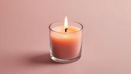 A lit candle in a glass holder on a soft pink background.
