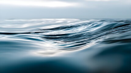 Close-up of gentle ocean waves with soft reflections on calm blue water