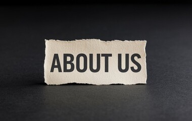 About us written on a piece of paper isolated on black background