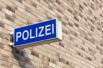 Obraz premium Polizei logo sign at the German police station. ochre brick wall background