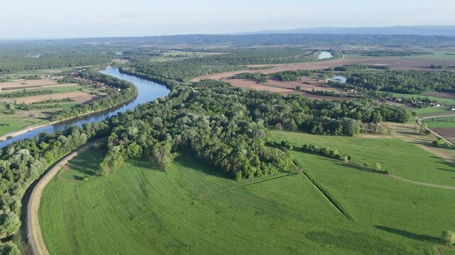 Aerial Drone View of River Winding Through Green Agricultural Landscape and Forests