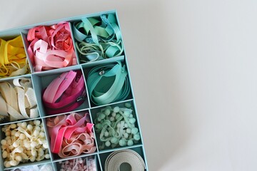 Colorful ribbons, cords and zippers in blue box on white background