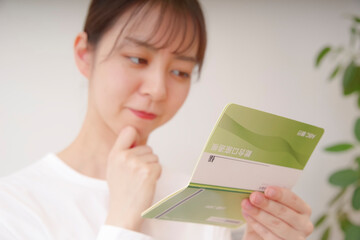 通帳を見て複雑な表情をする女性
