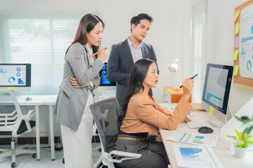 Marketing team collaborating on a project, using data visualization software to analyze charts and graphs for improving performance in a modern office workspace