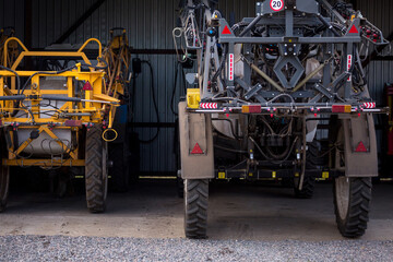 Trailed sprayer with tank capacities are standing in the arches hangar on the material and technical base of the agricultural enterprise. Farm enterprise in central region of Ukraine.