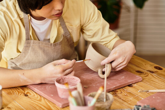 Creative process in a vibrant pottery studio as an artist shapes a unique handcrafted mug
