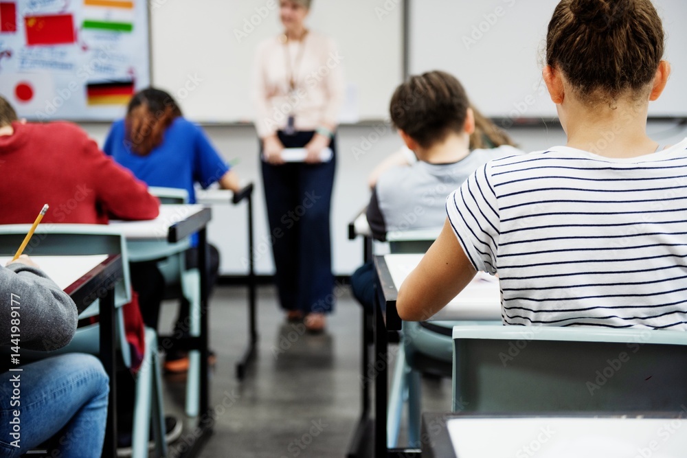 Poster students in a classroom taking a test. classroom setting with students focused on their test. female