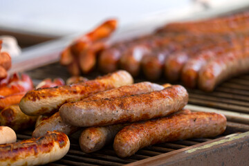 Close-up of frying sausages heated on grill at town square named Bellevue at Swiss City of Zürich on a spring day. Photo taken April 28th, 2025, Zurich, Switzerland.