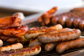 Close-up of frying sausages heated on grill at town square named Bellevue at Swiss City of Zürich on a spring day. Photo taken April 28th, 2025, Zurich, Switzerland.