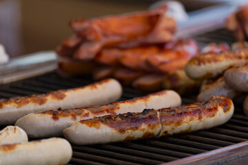 Close-up of frying sausages heated on grill at town square named Bellevue at Swiss City of Zürich on a spring day. Photo taken April 28th, 2025, Zurich, Switzerland.