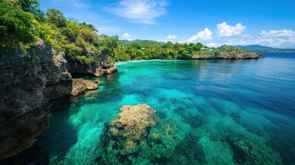 A vibrant tropical coastline featu clear turquoise waters, lush green cliffs, a sandy beach, and a bright blue sky with scattered clouds in a scenic island destination