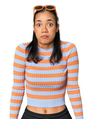 Young Filipino woman in studio shrugs shoulders and open eyes confused.
