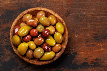 An assortment of various olives presented in a bowl, showcasing different colors, textures, and flavors