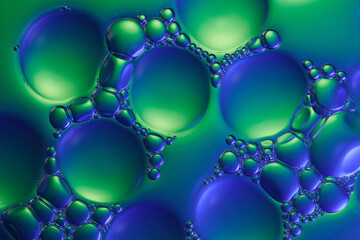 Essence liquid sample on water background with blue and green light reflecting on the surface of...