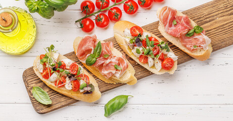 Tasty antipasto toasts featuring classic caprese with mozzarella and tomatoes, and savory prosciutto with herbs