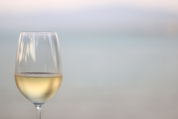 glass of cold white wine on the summer seashore by the water, relaxing by the water, a gentle background of soft color