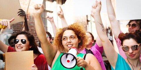 Diverse group of people at a protest. Women and men holding signs, raising fists. Energetic protest...