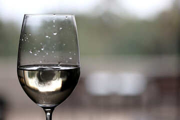 Wine glass close-up in real life, beautiful blurred background of the drink in the glass