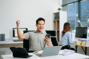 Fototapeta premium Asian businessman are delighted and happy with the work they do on their tablet, laptop and taking notes