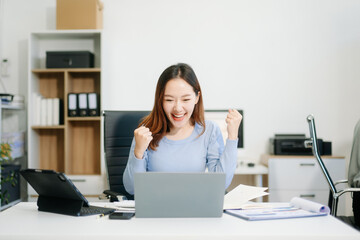 Business woman using tablet and laptop for doing math finance on an office desk, tax,