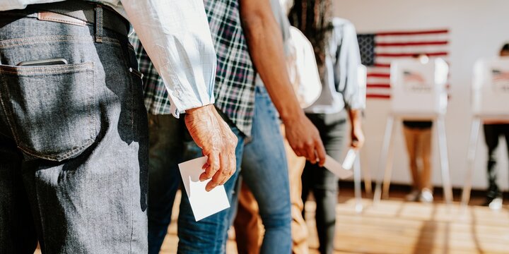 Diverse people in line voting in election, holding ballots. Voting in election, diverse group of people casting ballots. Diverse people voting, US election, close up photo of hand holding ballots