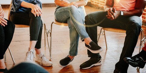 Diverse group of people sit in circle, participating in group discussion. Group discussion with...
