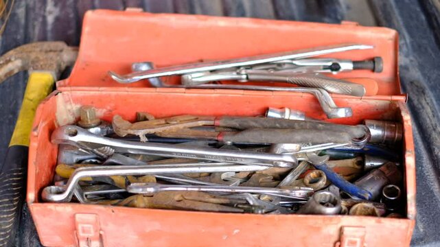A toolbox full of tools including a hammer, pliers, and wrenches. The tools are scattered around the box and some are in the box